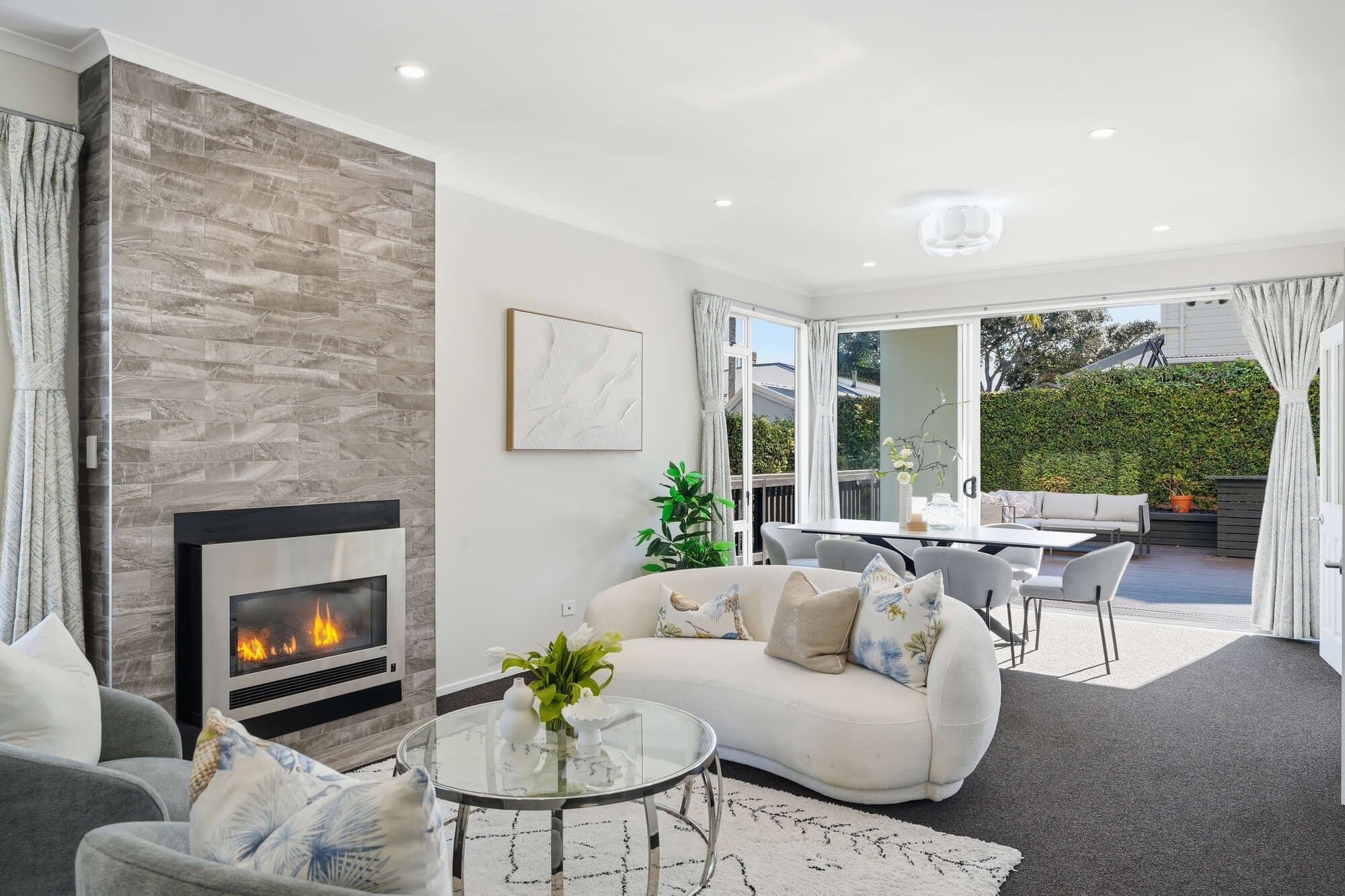 Living room with a stone fireplace and glass doors to the deck