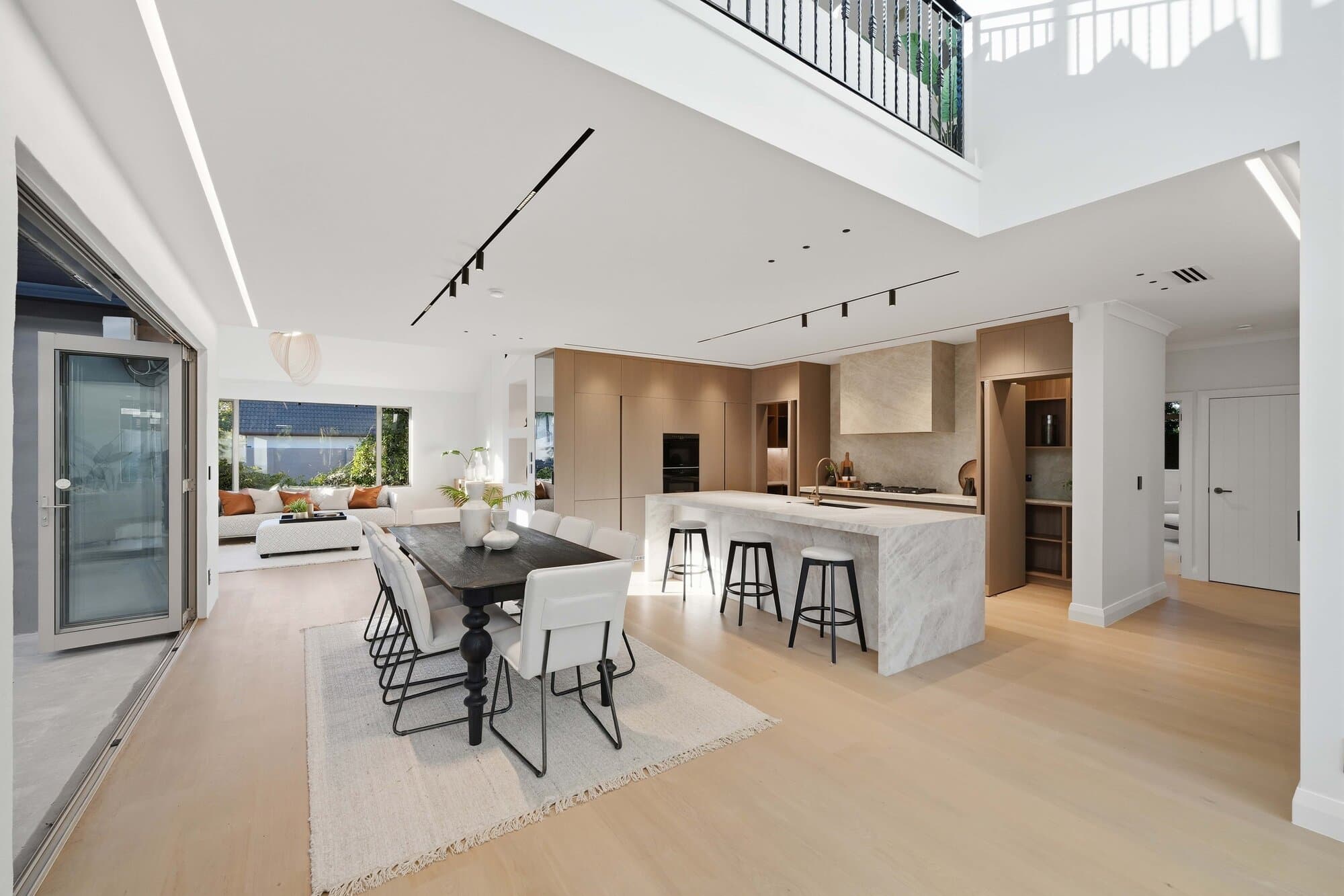 Kitchen and dining wide angle beneath a soaring mezzanine