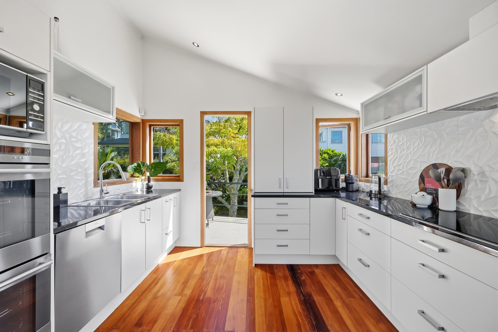 Kitchen finished in black cabinetry and timber flooring
