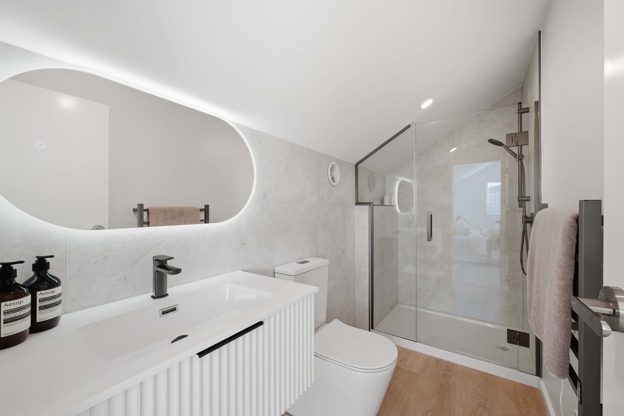Bathroom with an oval mirror and walk-in shower