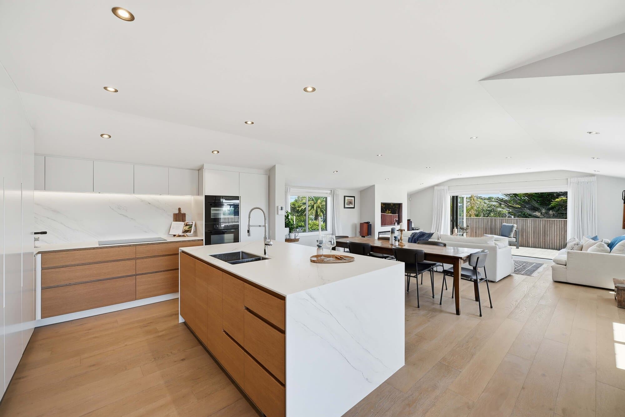Kitchen and living space with timber island and sea views