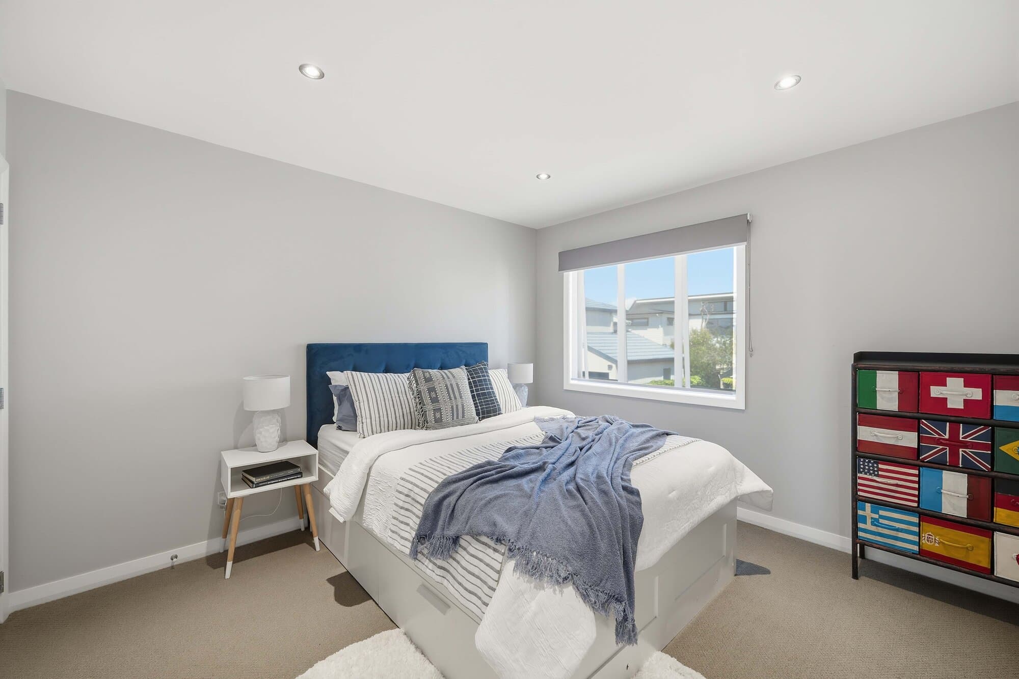 Bedroom with blue trim and a colourful cabinet