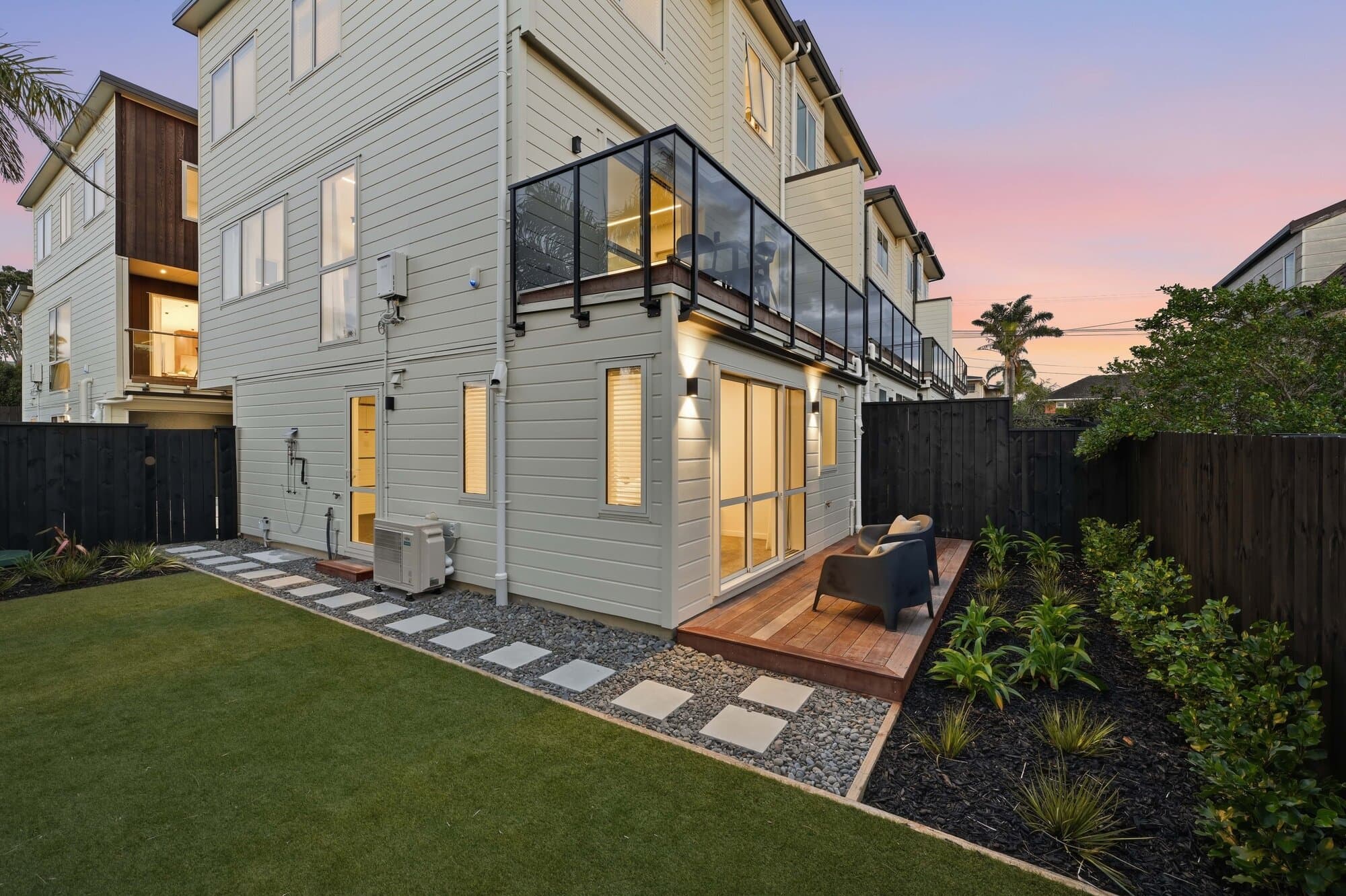 3 Corrella Road exterior at dusk, deck lit against the sky